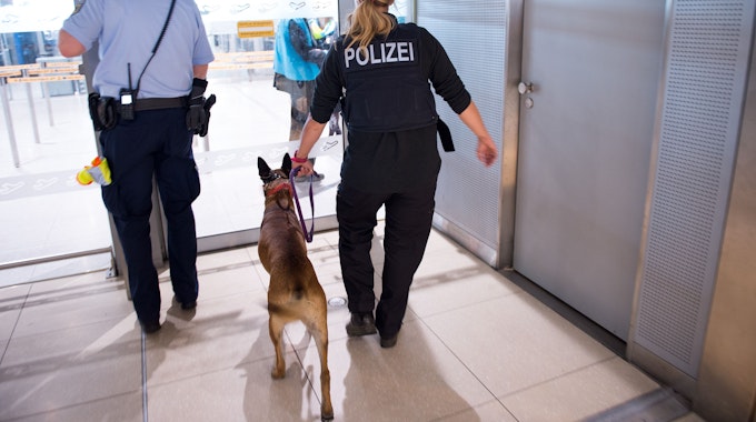 Polizisten mit einem Hund betreten 30.05.2016 den Sicherheitsbereich im Terminal 1 am Flughafen Köln/Bonn (Nordrhein-Westfalen).