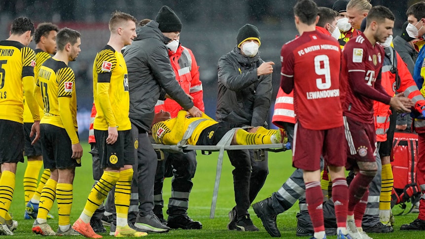 Dortmunds Julian Brandt wird verletzt vom Platz getragen.
