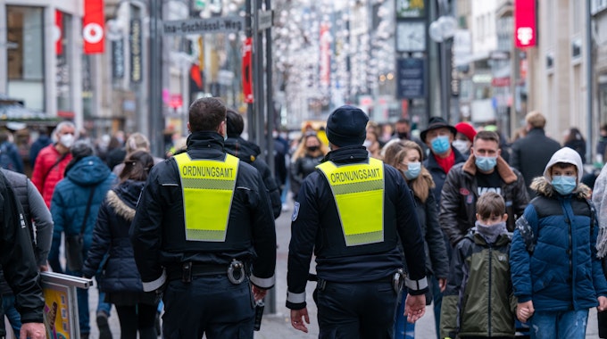 Köln: Mitarbeiter des Ordnungsamtes erinnern Passanten an die Maskenpflicht. In den Einkaufsstraßen gilt auch im zweiten Coronawinter die Maskenpflicht und die 2G-Regel für den Zutritt in Geschäfte.