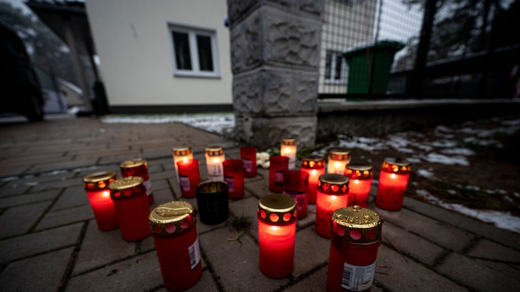 Vor dem Einfamilienhaus in Senzig, einem Ortsteil der Stadt Königs Wusterhausen im Landkreis Dahme-Spreewald, stehen Kerzen. Die Polizei hat dort fünf Tote in einem Wohnhaus gefunden. Die Polizei geht von einem Tötungsverbrechen aus, sagte ein Sprecher.