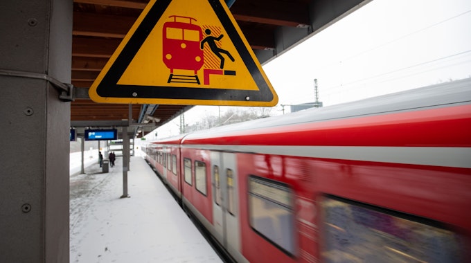 Das Symbolbild zeigt ein Schild, das an einem S-Bahnsteig vor der Gefahr, auf das Gleis zu fallen, warnt.