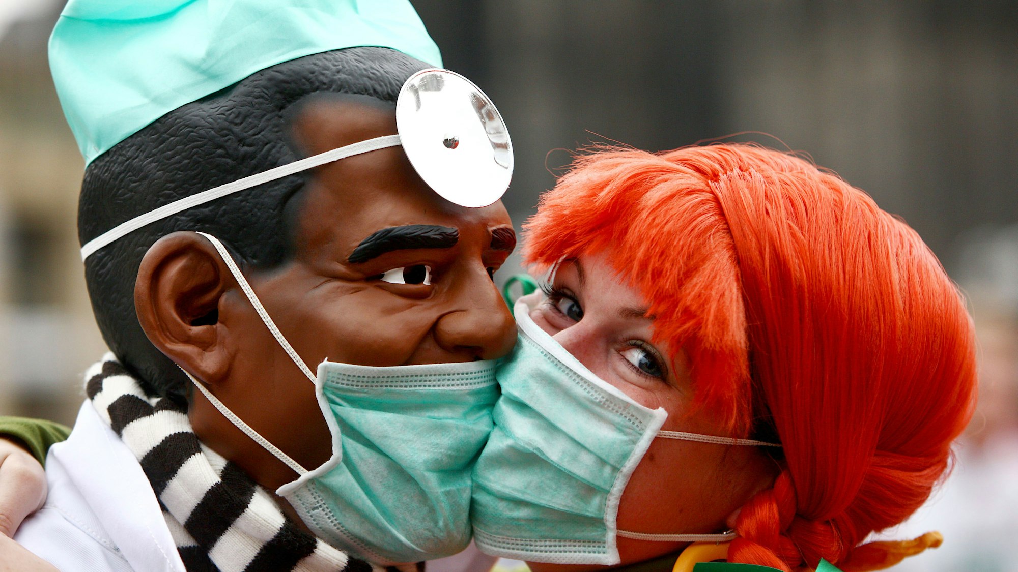 Zwei Narren "bützen" (küssen) sich am Mittwoch (11.11.2009) in Köln aus Angst vor einer Ansteckung mit der Schweingrippe mit Schutzmasken. Schlag 11 Uhr 11 hat in den rheinischen Karnevalshochburgen die fünfte Jahreszeit begonnen.