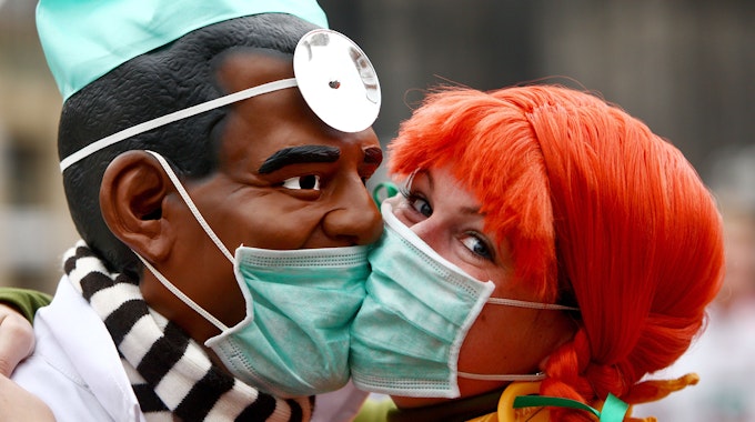 Zwei Narren "bützen" (küssen) sich am Mittwoch (11.11.2009) in Köln aus Angst vor einer Ansteckung mit der Schweingrippe mit Schutzmasken. Schlag 11 Uhr 11 hat in den rheinischen Karnevalshochburgen die fünfte Jahreszeit begonnen.