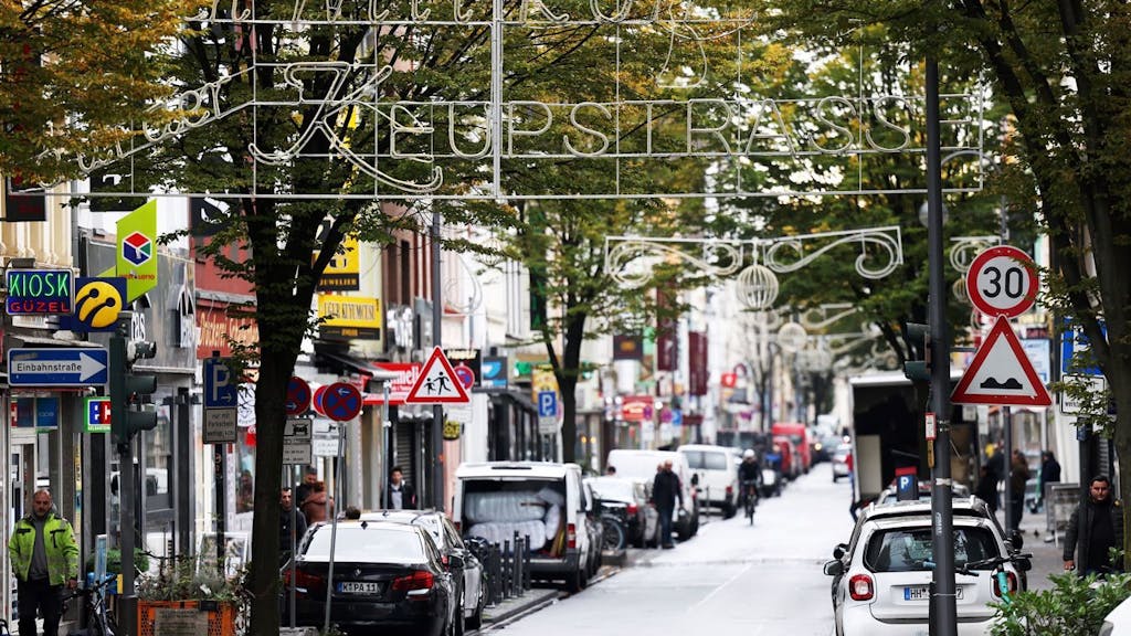 Köln: Die Keupstrasse mit mehreren Geschäften, Fußgängern und Autos.&nbsp;