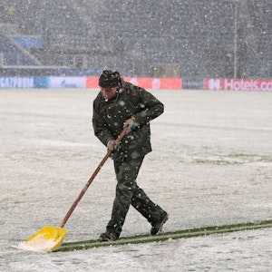 Ein Helfer schippt beim Spiel von Atalanta Bergamo gegen Villarreal Schnee.