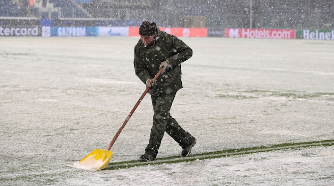 Ein Helfer schippt beim Spiel von Atalanta Bergamo gegen Villarreal Schnee.