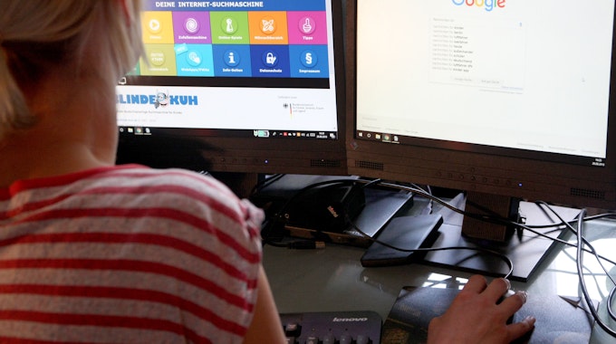 Eine Frau betrachtet am 15. August 2018 auf zwei Bildschirmen unterschiedliche Suchmaschinen