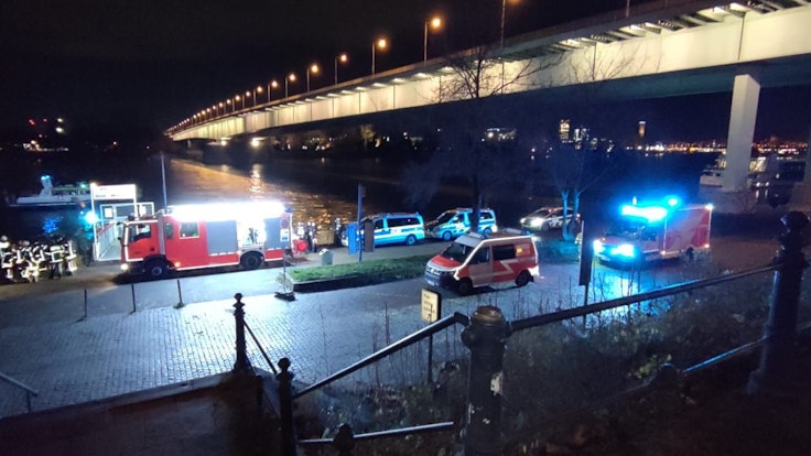 Polizei und Feuerwehr stehen am Rheinufer unter der Zoobrücke.