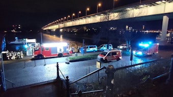 Polizei und Feuerwehr stehen am Rheinufer unter der Zoobrücke. Dort war ein Taxi in den Rhein gefahren.