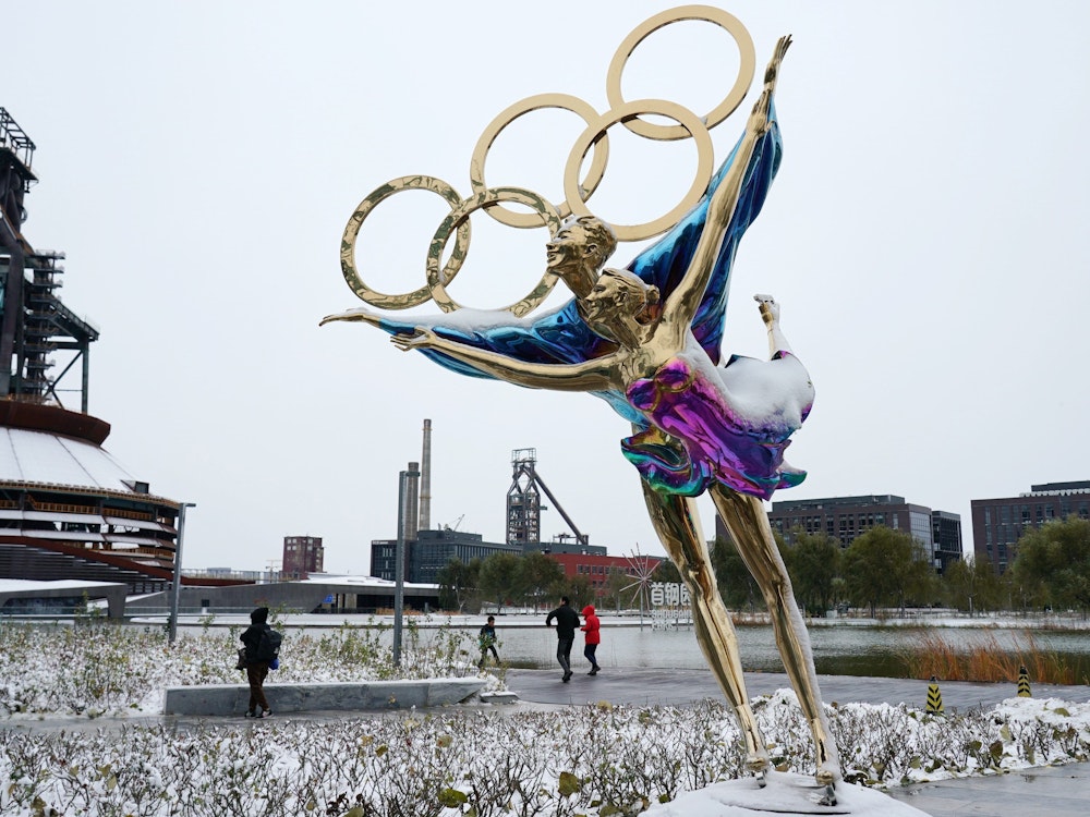 Eine Figur im Shougang-Park ist mit Schnee bedeckt. Winter-Olympia in China wird für die Organisatoren immer mehr zu Problemspielen.