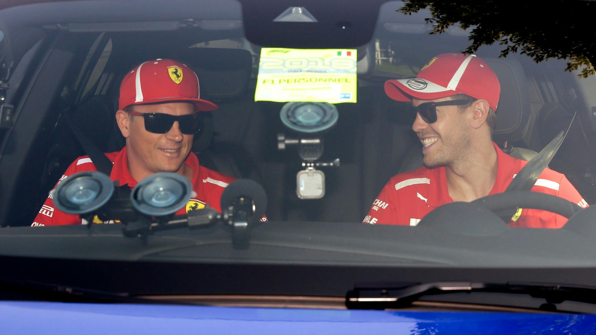 Vor der Pressekonferenz des Weltverbands zum Grand Prix von Italien in Monza 2018 sitzen die damaligen Ferrari-Piloten Sebastian Vettel (r) und Kimi Räikkönen im Auto.