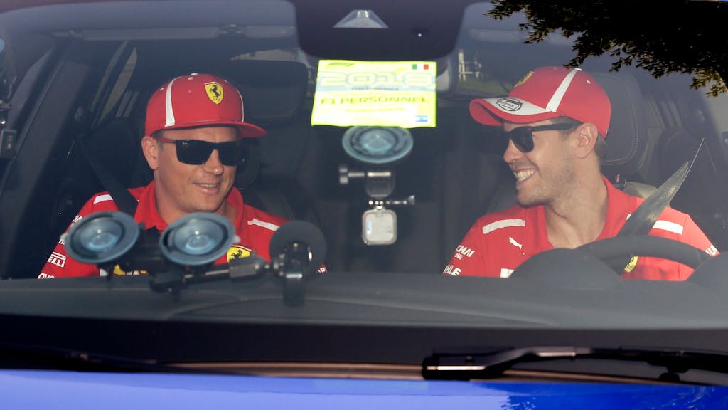 Vor der Pressekonferenz des Weltverbands zum Grand Prix von Italien in Monza 2018 sitzen die damaligen Ferrari-Piloten Sebastian Vettel (r) und Kimi Räikkönen im Auto.&nbsp;