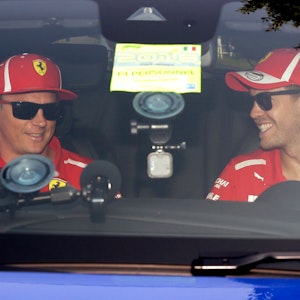 Vor der Pressekonferenz des Weltverbands zum Grand Prix von Italien in Monza 2018 sitzen die damaligen Ferrari-Piloten Sebastian Vettel (r) und Kimi Räikkönen im Auto.