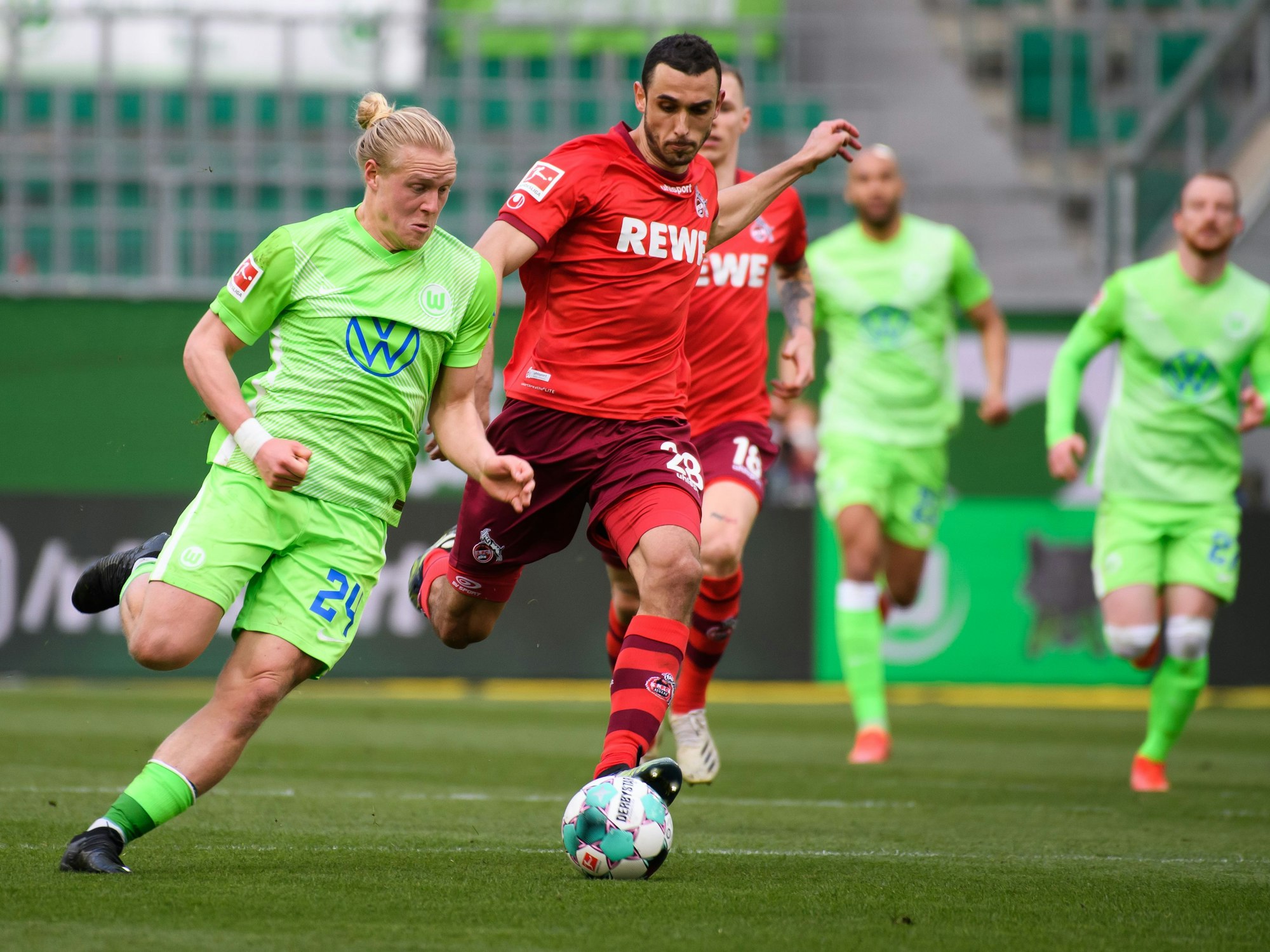 Wolfsburgs Xaver Schlager (l) spielt gegen Kölns Ellyes Skhiri.
