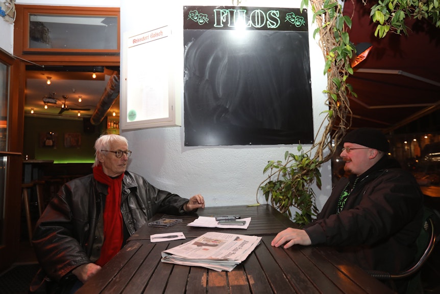 Horst Stellmacher (l.) mit Art Garfunkel jr. sitzen sich an einem Tisch gegenüber.