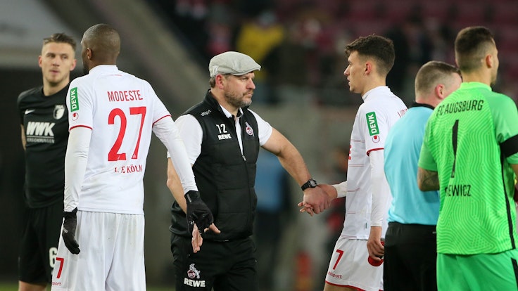 Trainer Steffen Baumgart klatscht nach der Niederlage gegen den FC Augsburg (10. Dezember 2021) mit Dejan Ljubicic und Anthony Modeste ab.