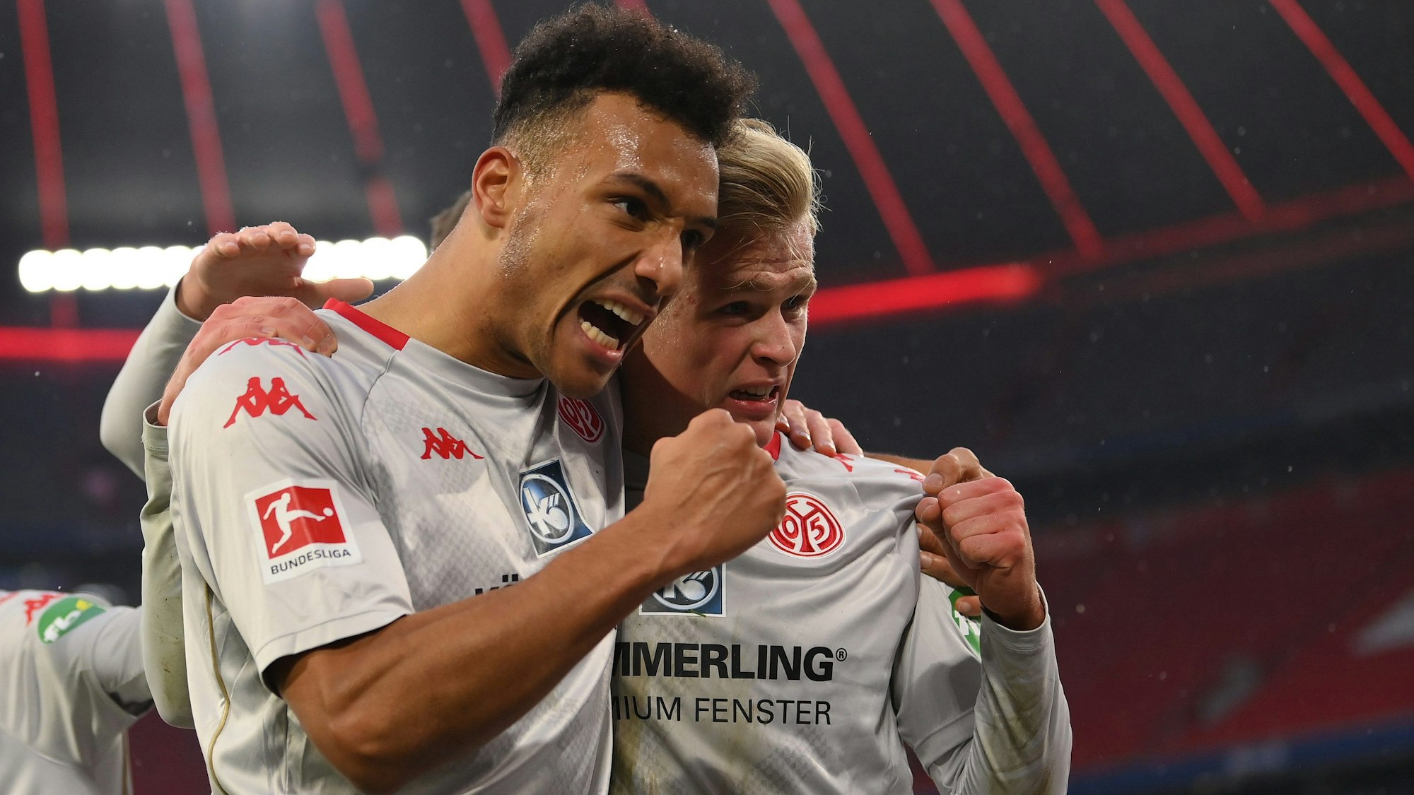Karim Onisiwo und Jonathan Burkardt bejubeln ein Tor von Mainz 05 gegen den FC Bayern.