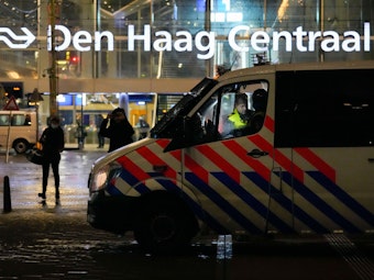 Fahrzeuge der niederländischen Polizei stehen Ende November vor einem Bahnhof in Den Haag: Die Behörden haben einen Mann festgenommen, der im Internet ein ominöses Corona-Kit verkauft hat.