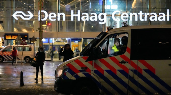 Fahrzeuge der niederländischen Polizei stehen Ende November vor einem Bahnhof in Den Haag: Die Behörden haben einen Mann festgenommen, der im Internet ein ominöses Corona-Kit verkauft hat.