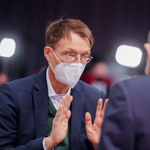 Bundeskanzler Olaf Scholz (SPD) und Karl Lauterbach (l, SPD), Bundesminister für Gesundheit, unterhalten sich beim Bundesparteitag ihrer Partei.