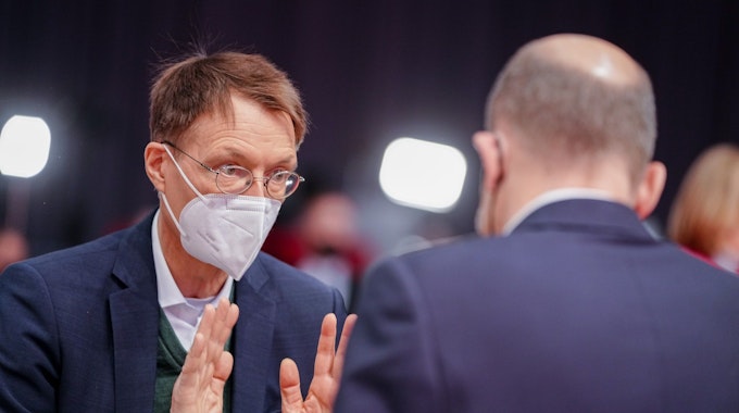 Bundeskanzler Olaf Scholz (SPD) und Karl Lauterbach (l, SPD), Bundesminister für Gesundheit, unterhalten sich beim Bundesparteitag ihrer Partei.