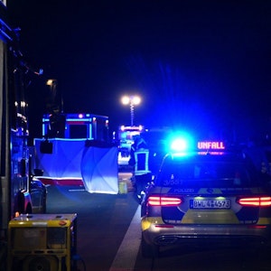 Einsatzfahrzeuge von Polizei und Feuerwehr stehen mit Blaulicht an der Unfallstelle.