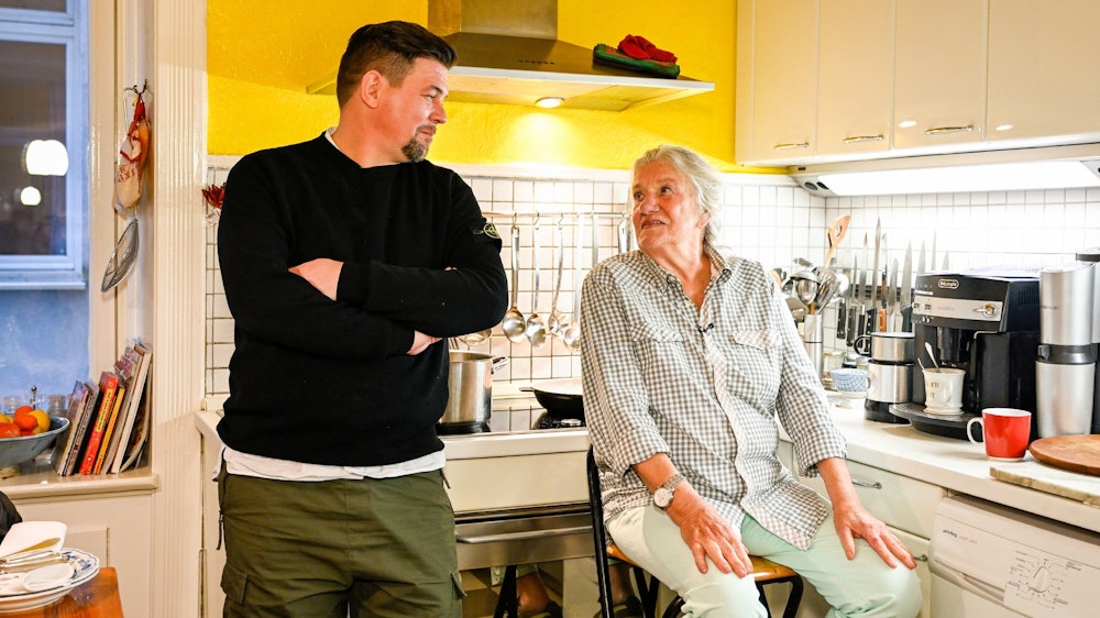 Das Foto zeigt Tim Mälzer und Kandidatin Monika Fuchs beim Plaudern in der Küche während der TV-Show „Kitchen Impossible“ (Folge vom 12.12.2021).