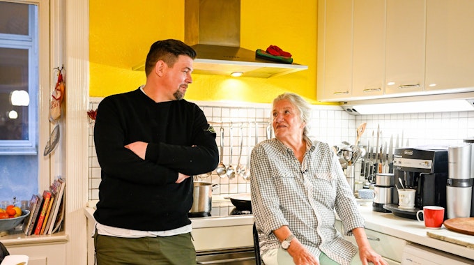 Das Foto zeigt Tim Mälzer und Kandidatin Monika Fuchs beim Plaudern in der Küche während der TV-Show „Kitchen Impossible“ (Folge vom 12.12.2021).