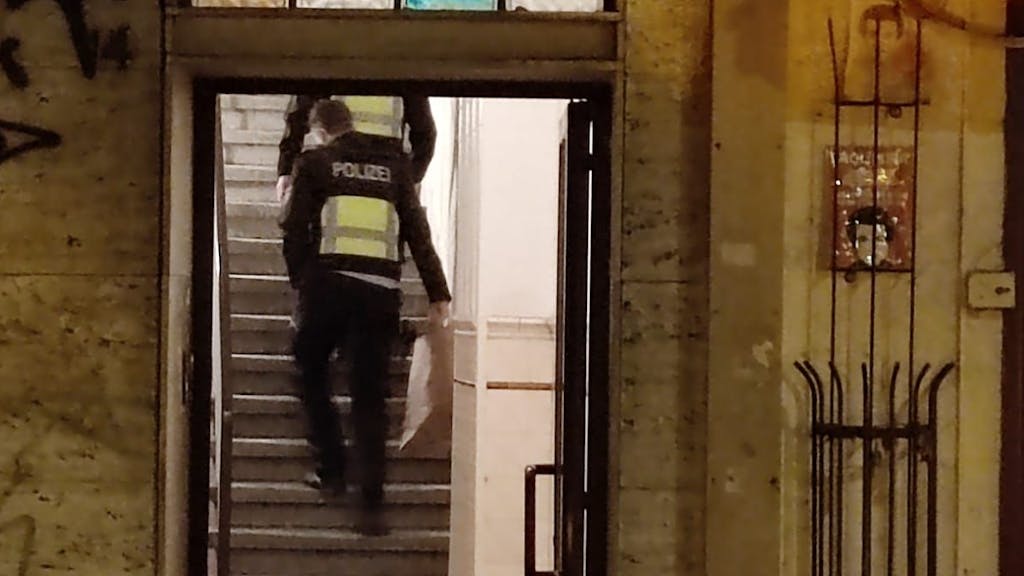 Zwei Polizisten gehen eine Treppe in einem Haus hoch.&nbsp;