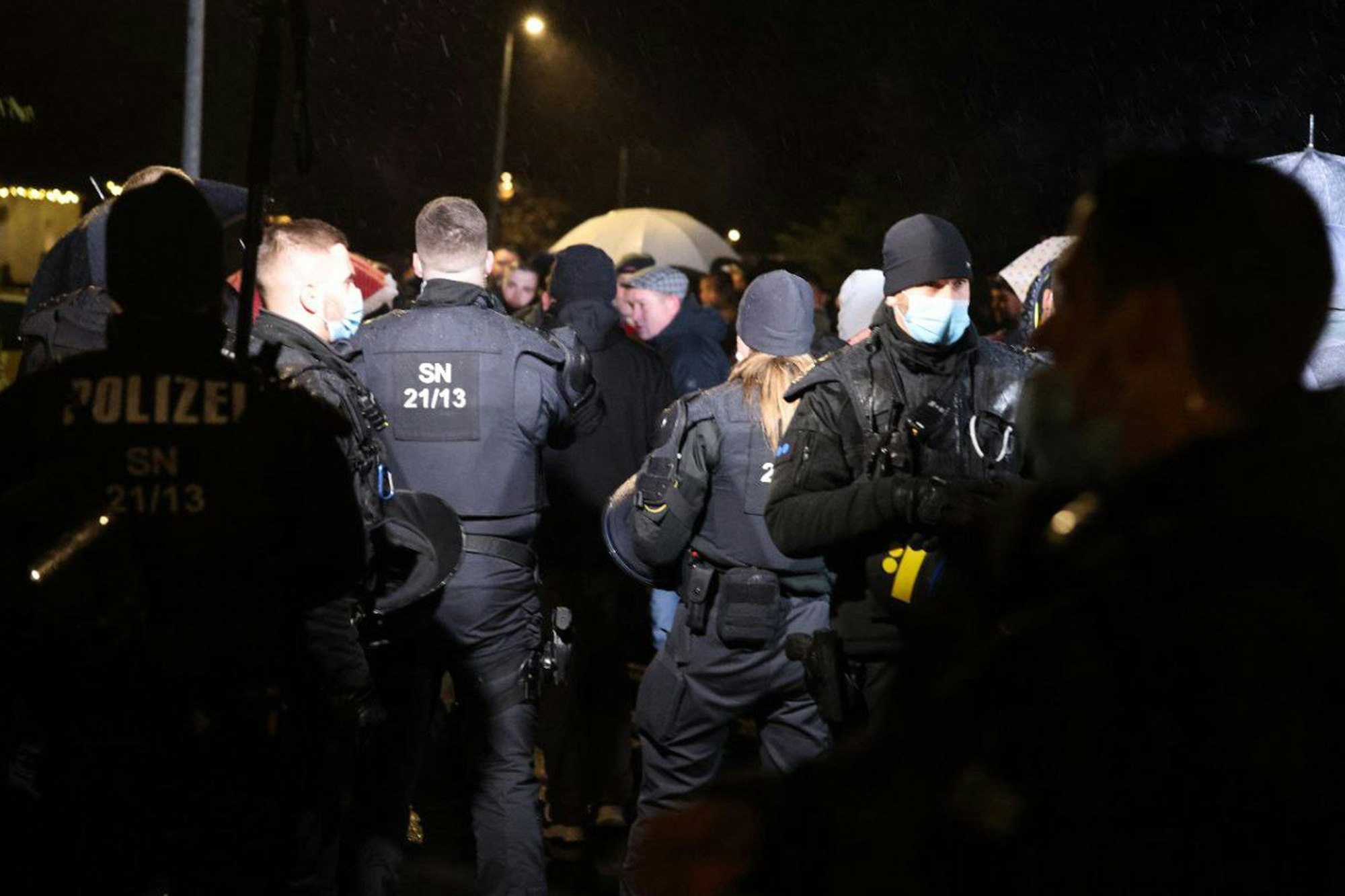 Polizisten beobachten mehrere Personen bei einer Gruppenbildung am 12.12.2021 im sächsischen Bennewitz. Versammlungen mit mehr als zehn Menschen sind wegen der Corona-Lage in Sachsen derzeit nicht gestattet.