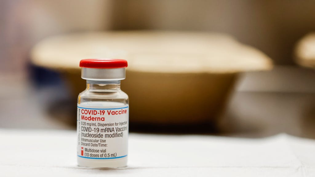 Eine Ampulle gefüllt mit dem Impfstoff «Moderna» steht auf einem Tisch in einem Impfzentrum. (Zu dpa: «Impfen rund um die Uhr - Aachen startet 60-Stunden-Aktion») +++ dpa-Bildfunk +++