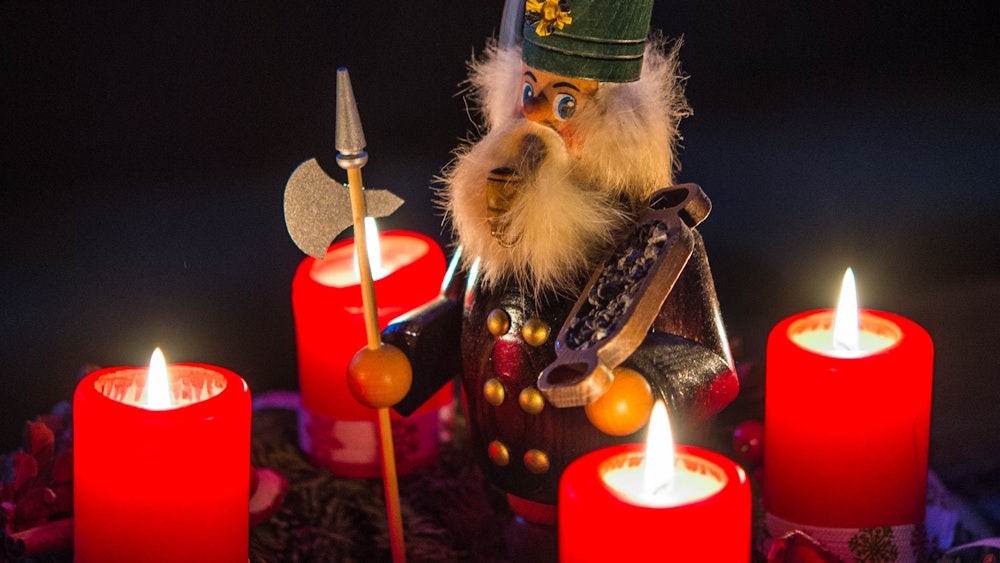 Ein qualmendes Räuchermännlein steht am 14.12.2014 in Sieversdorf (Brandenburg) inmitten eines Adventskranzes auf dem alle vier Kerzen brennen.