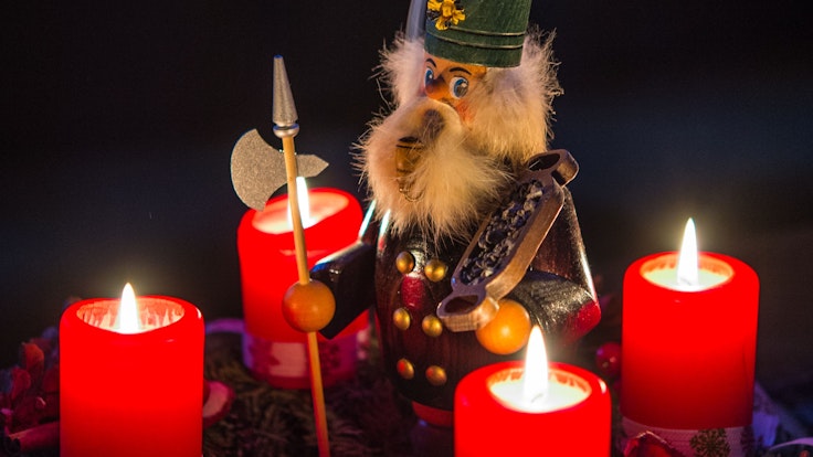 Ein qualmendes Räuchermännlein steht am 14.12.2014 in Sieversdorf (Brandenburg) inmitten eines Adventskranzes auf dem alle vier Kerzen brennen.