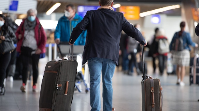 Ein Passagier läuft mit seinem Gepäck am Flughafen Frankfurt.