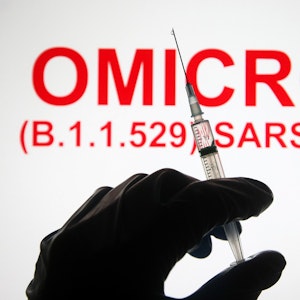 Eine Hand hält vor der Aufschrift «Omicron (B.1.1.529): SARS-CoV-2» eine Spritze hoch.