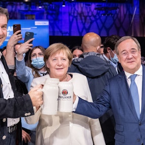 Beim offiziellen Wahlkampfabschluss von CDU und CSU in der Festhalle am Nockherberg stoßen Armin Laschet, Angela Merkel und Markus Söder mit Bierkrügen an.