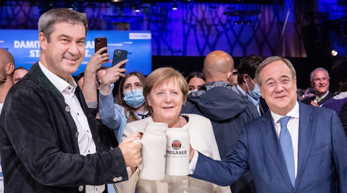 Beim offiziellen Wahlkampfabschluss von CDU und CSU in der Festhalle am Nockherberg stoßen Armin Laschet, Angela Merkel und Markus Söder mit Bierkrügen an.