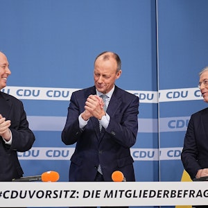 Friedrich Merz steht zwischen den Mitkandidaten für den Parteivorsitz Helge Braun und Norbert Röttgen nach der Bekanntgabe der Ergebnisse der CDU Mitgliederbefragung.