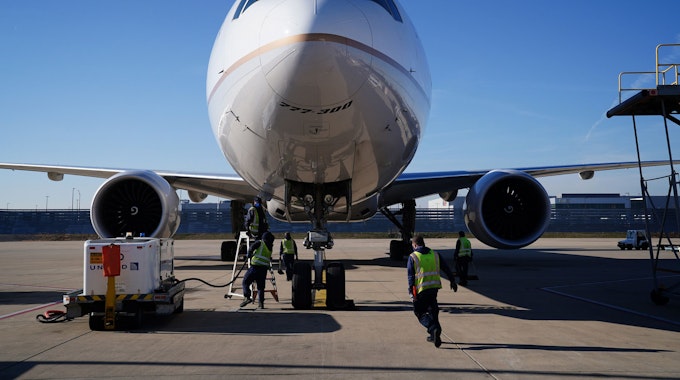 Frachtabfertiger bereiten sich auf das Entladen einer Boeing 777-300 vor.