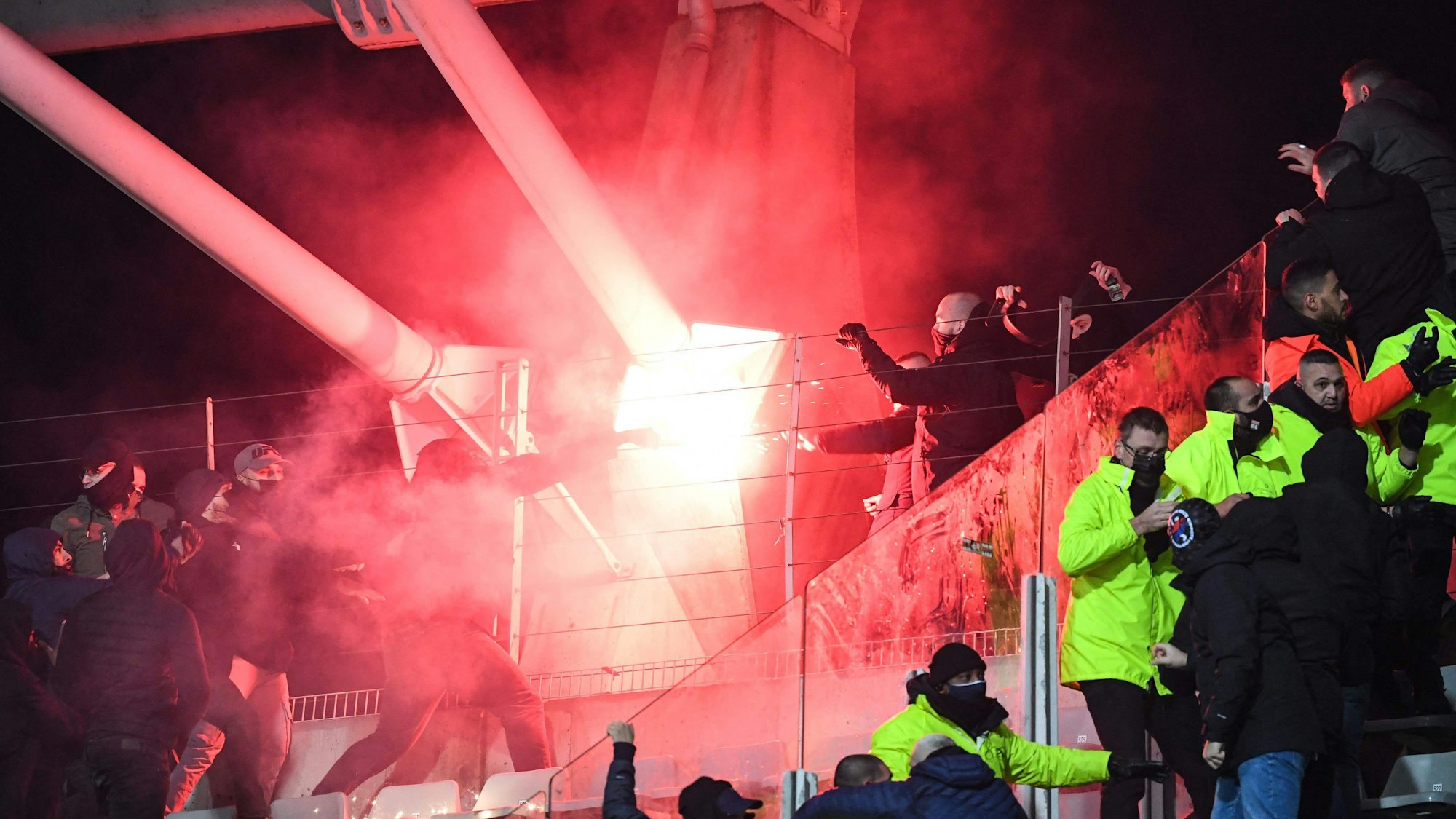 Fans halten im Stehblock während der Pokalpartie zwischen Paris FC und Olympique Lyon eine Pyro-Fackel hoch.
