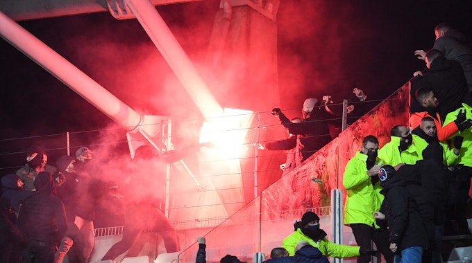 Fans halten im Stehblock während der Pokalpartie zwischen Paris FC und Olympique Lyon eine Pyro-Fackel hoch.