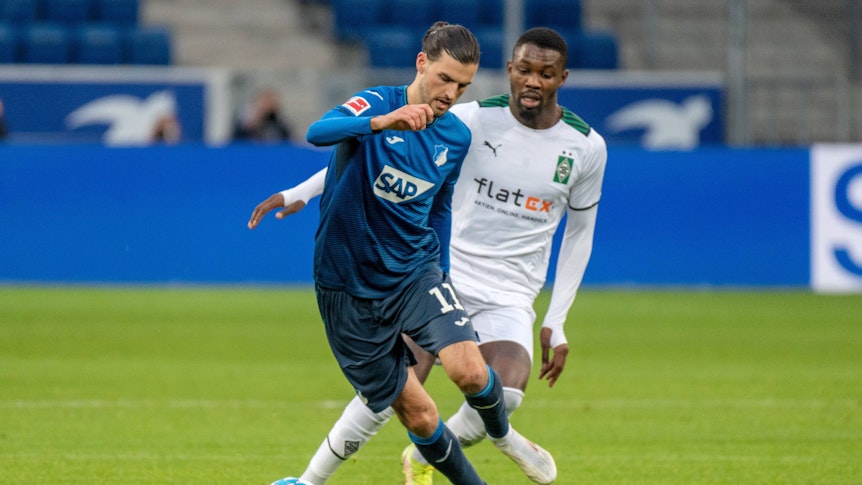 Florian Grillitsch (l.) von der TSG 1899 Hoffenheim gegen Marcus Thuram (r.) von Borussia Mnchengladbach am 18. Dezember 2021.