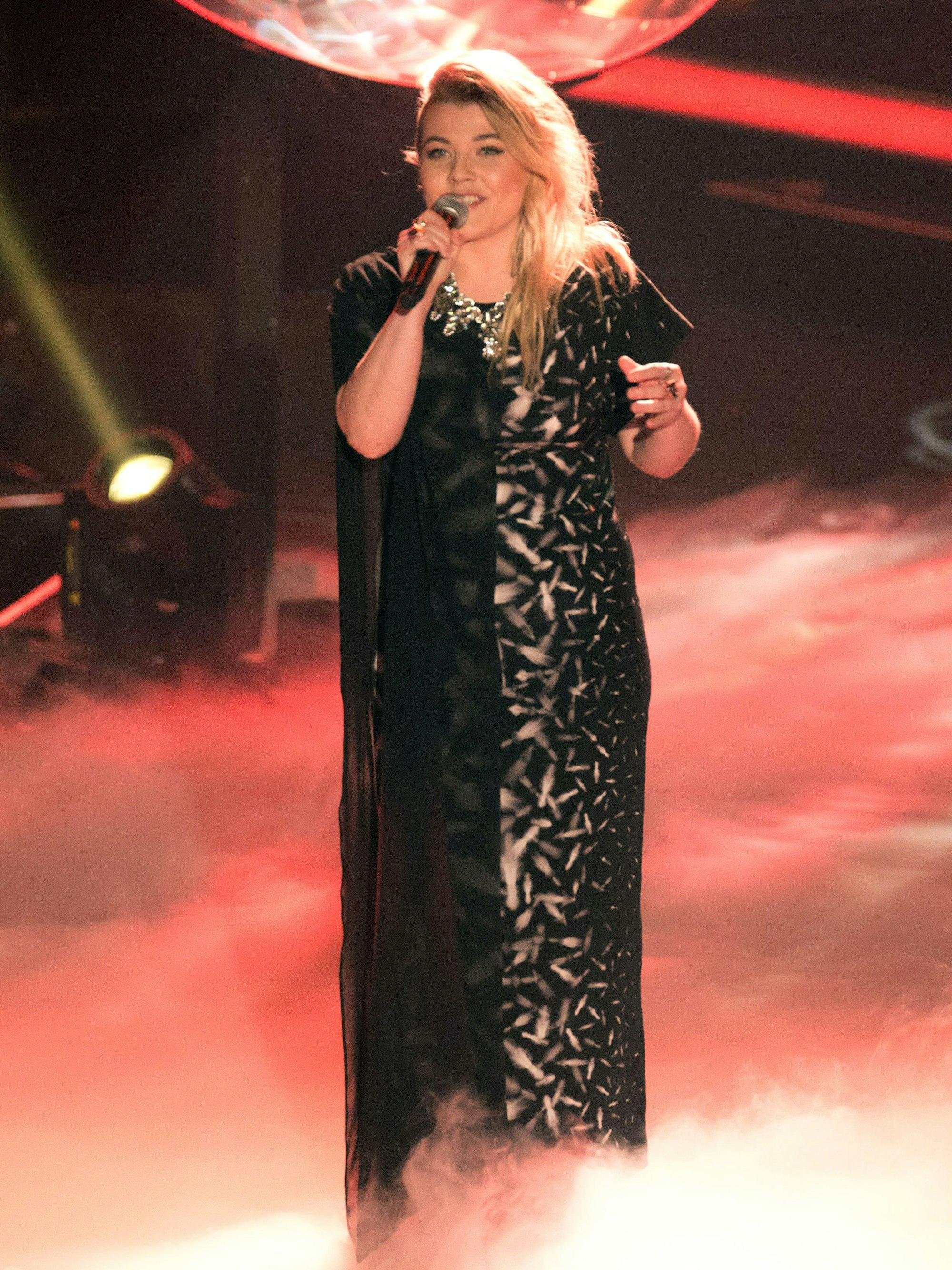 Die Sängerin Charley Ann Schmutzler steht auf der Bühne und singt.