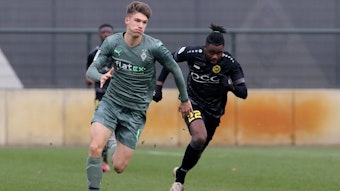 Tom Gaal (l.) von Borussia Mönchengladbach im Laufduell mit Mamodou Lamin Jallow (r.) vom VfB Homberg am 11. Dezember 2021.
