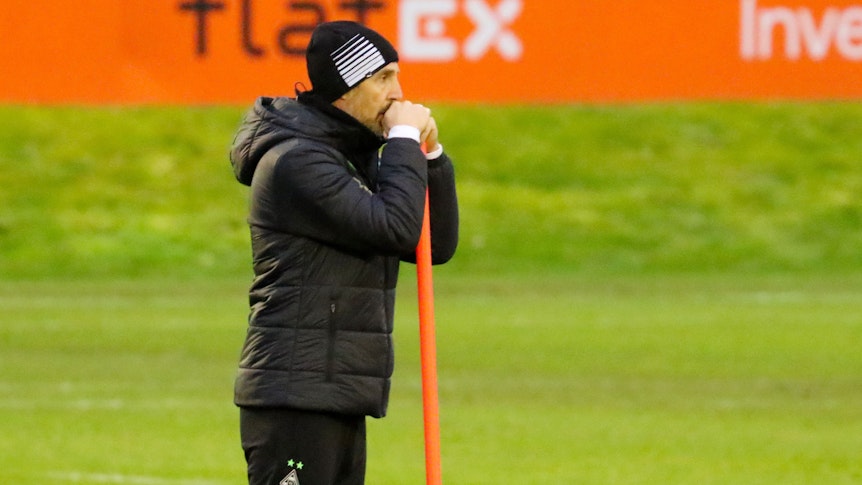 Adi Hütter, Trainer von Borussia Mönchengladbach lehnt auf einem orangenen Stab beim Training am Borussia-Park am 13. Dezember 2021.