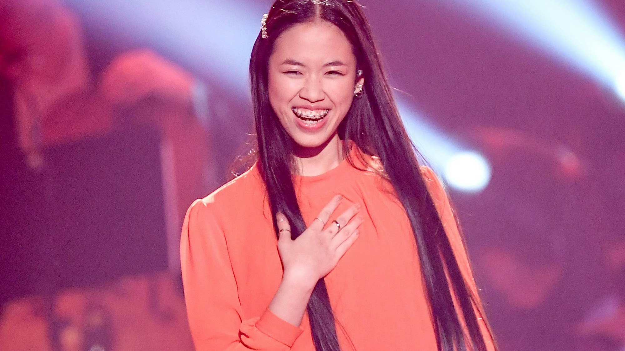 Claudia Emmanuela Santoso, Sängerin und Finalistin der Castingshow „The Voice of Germany“, steht beim Finale auf der Bühne und lächelt.