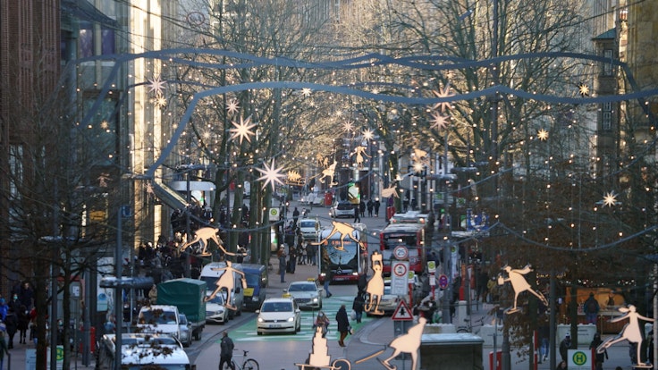 Passanten erledigen Einkäufe am 21. Dezember in der weihnachtlich geschmückten Innenstadt von Hamburg. Das Bundesland verschärft seine Corona-Maßnahmen für Heiligabend.