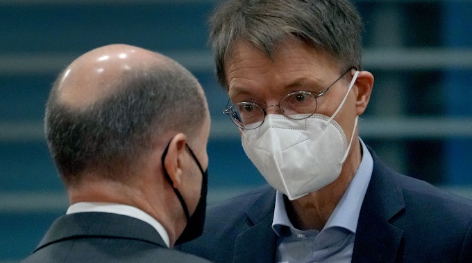Bundeskanzler Olaf Scholz (l) und Bundesgesundheitsminister Karl Lauterbach (beide SPD) unterhalten sich bei ihrer Ankunft zur wöchentlichen Kabinettssitzung im Kanzleramt und tragen einen Mund-Nasenschutz. +++ dpa-Bildfunk +++