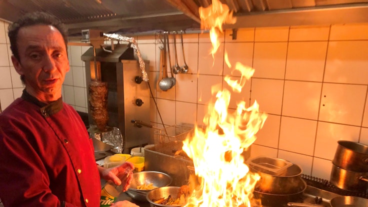 Dimi Sol flambiert in der Küche zwei Entenbrüste in der Pfanne.