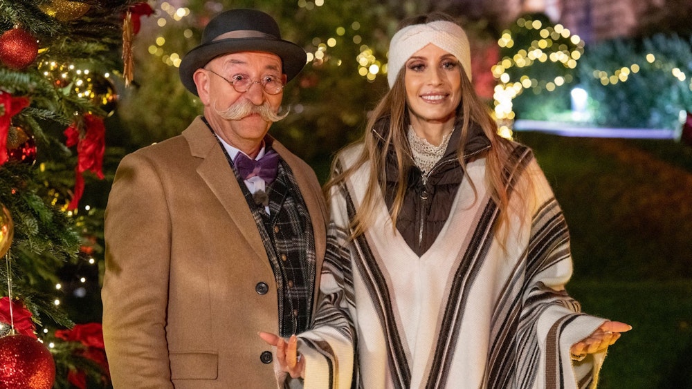 Horst Lichter und Cathy Hummels stehen bei der Weihnachtsaugabe „Bares für Rares XXL“ vor einem Weihnachtsbaum.